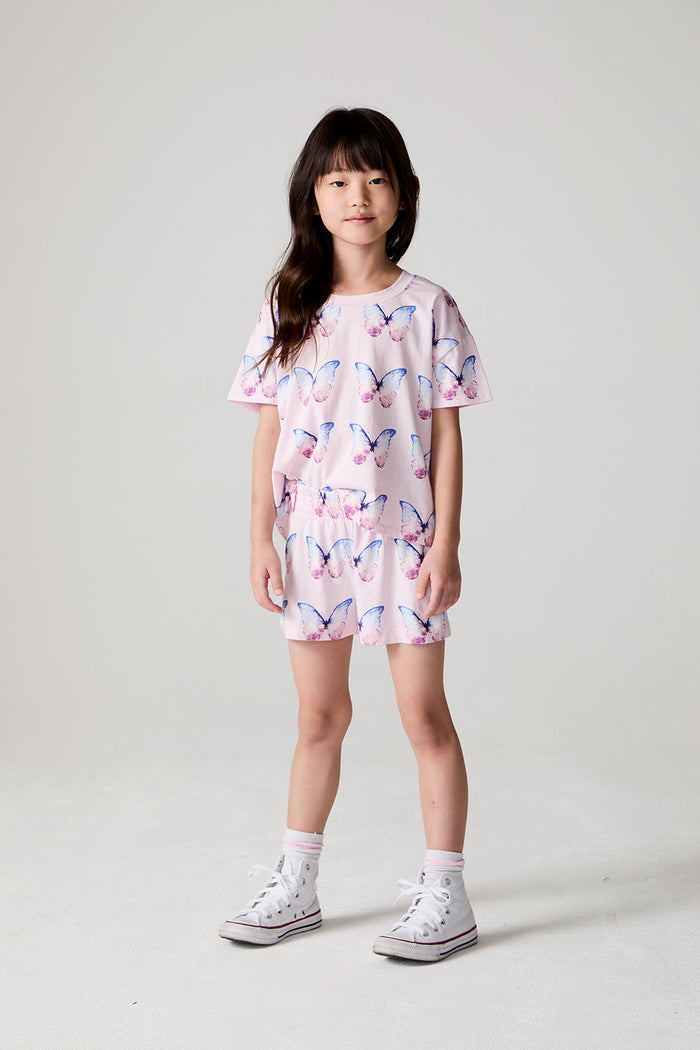 Front view of a girl wearing the Chaser  Flutter Butterfly Shorts and matching shirt on a neutral background