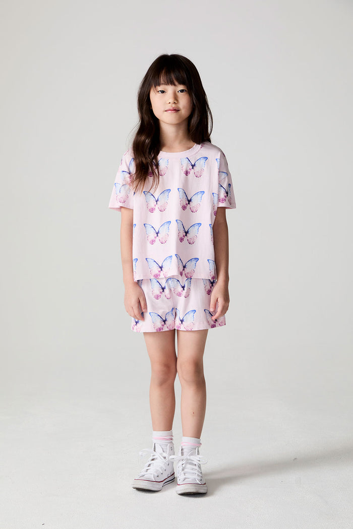 Full body front view of a girl wearing the Chaser Flutter Butterfly Tee on a neutral background
