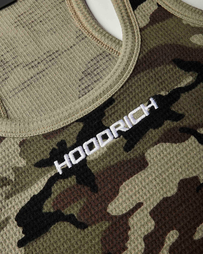 Close-up of a camouflage knit top with a white embroidered 'HOODRICH' logo across the chest.