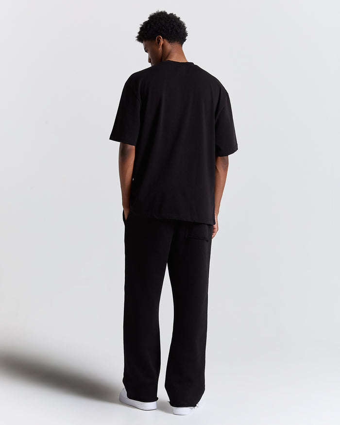 Person wearing a black outfit on a plain background