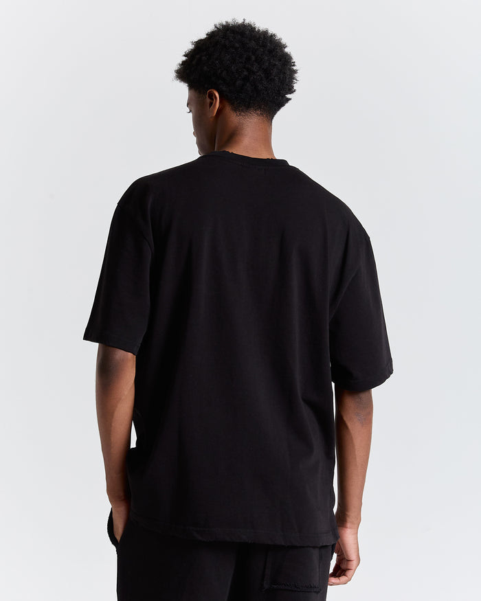 Person wearing a black t-shirt on a plain background