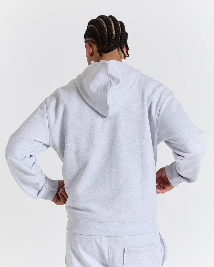 Back view of a male model wearing a relaxed grey marl zip-up hoodie.