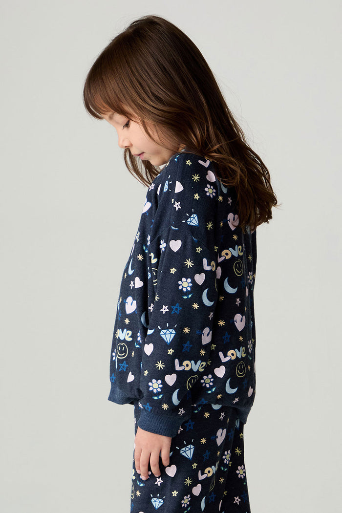 Side view of a girl wearing the Chaser Free Draw Girls Tee and pants on a neutral background
