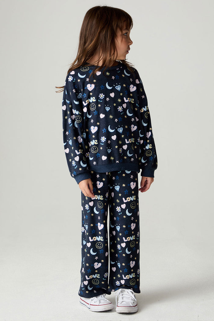 Full body front view of a girl wearing the Chaser Free Draw Girls Tee and pants on a neutral background looking to one side