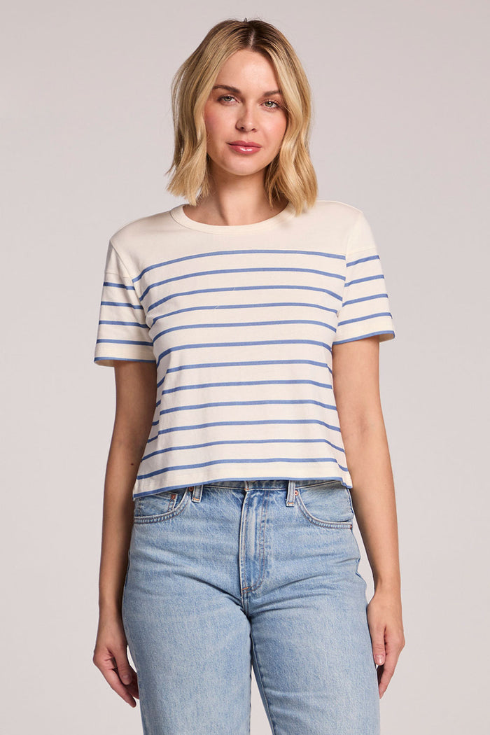 Front view of a woman wearing the Chaser French Riviera Stripe Jameson Tee and jeans on a neutral background