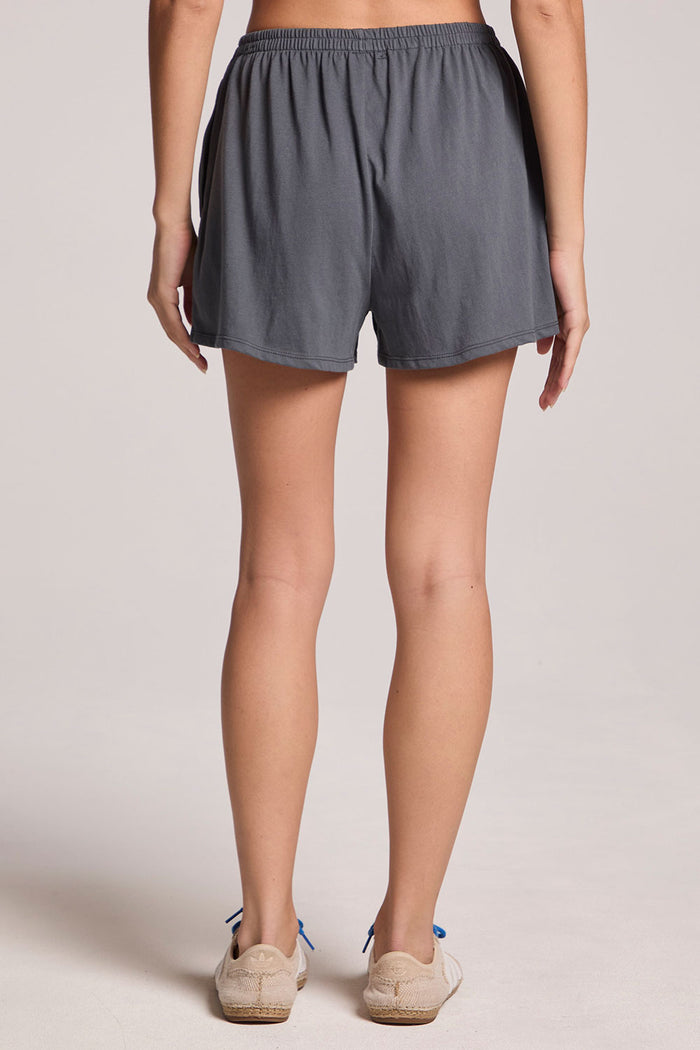 Back front view of a woman wearing the Chaser Future Grey Harper Shorts and sneakers on a neutral background