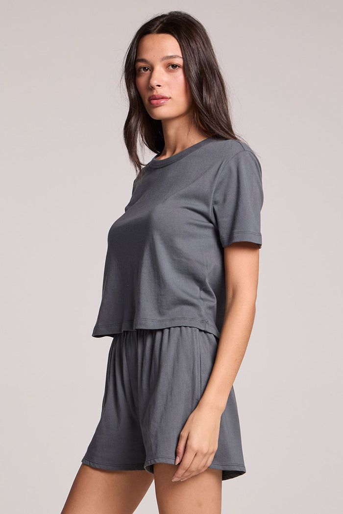 Side angle view of a woman wearing the Chaser Future Grey Jameson Tee and matching Harper shorts on a neutral background