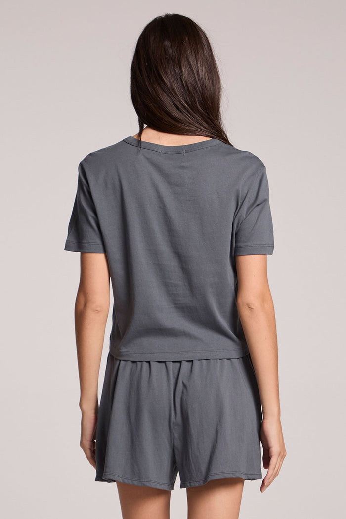 Back view of a woman wearing the Chaser Future Grey Jameson Tee and matching shorts on a neutral background