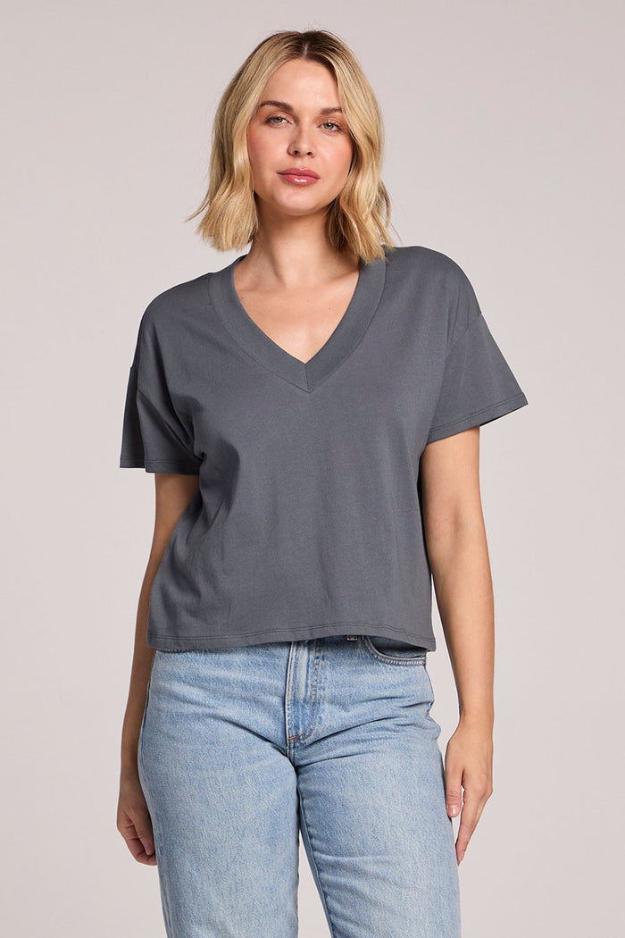 Front view of a woman wearing the Chaser Future Grey Mazzy Tee and jeans on a neutral background