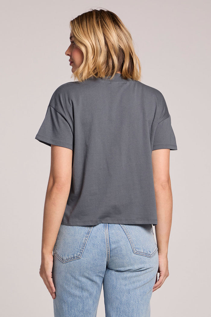 Back view of a woman wearing the Chaser Future Grey Mazzy Tee on a neutral background