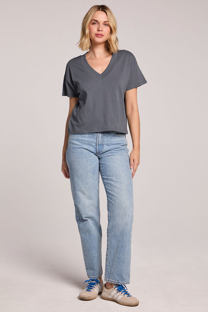 Full body front view of a woman wearing the Chaser Future Grey Mazzy Tee and jeans on a neutral background