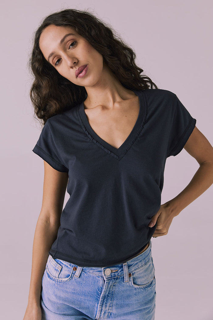 Straight-on studio image of the Chaser Gator V Neck Licorice Black Tee highlighting clean neckline seam and easy drape over jeans
