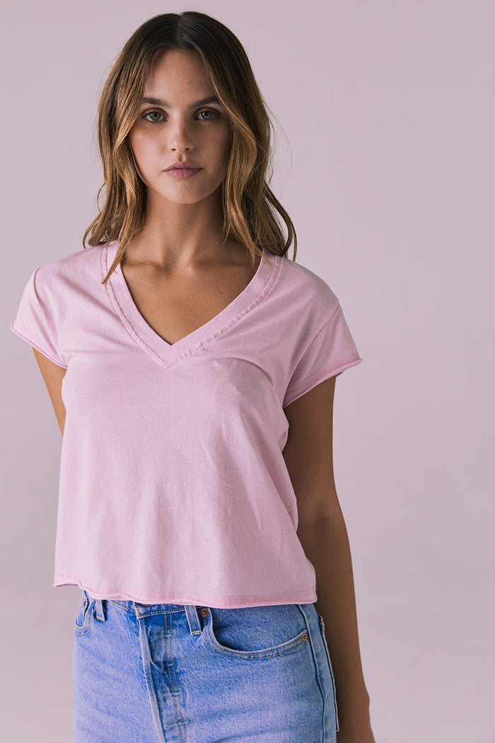Front studio image of the Chaser Gator V Neck Nose Pink Tee styled with light-wash denim showing soft neckline and relaxed cropped fit