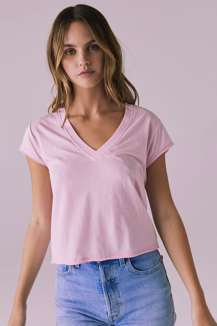 Studio image of the Chaser Gator V Neck Nose Pink Tee walking forward in denim jeans capturing soft movement and effortless style