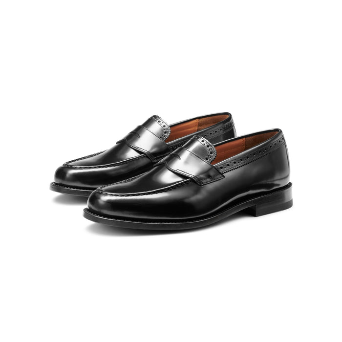 Black leather penny loafers with perforated brogue trim, angled pair view.