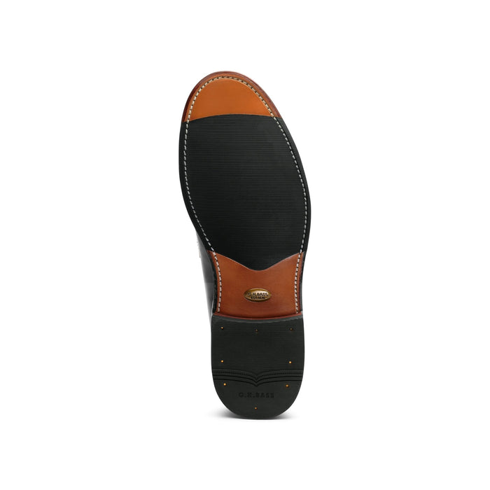 Sole of a black leather loafer, tan leather with G.H. Bass branding.