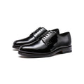 Black patent leather lace-up derby shoes, three-quarter angle pair view.