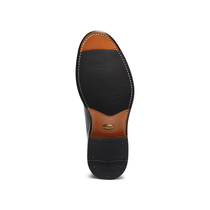 Sole of a black patent leather derby shoe, tan leather with G.H. Bass branding.