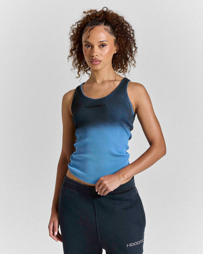 Model wearing a black and blue ombre fitted racer vest with a small Hoodrich logo on the chest.