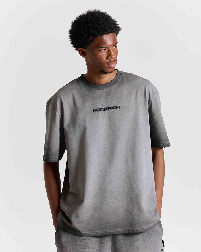 Male model wearing an oversized black oil wash t-shirt with a center chest Hoodrich logo.