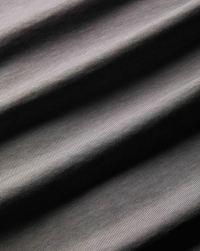 Extreme close-up of the fabric texture on an oversized black oil wash t-shirt.