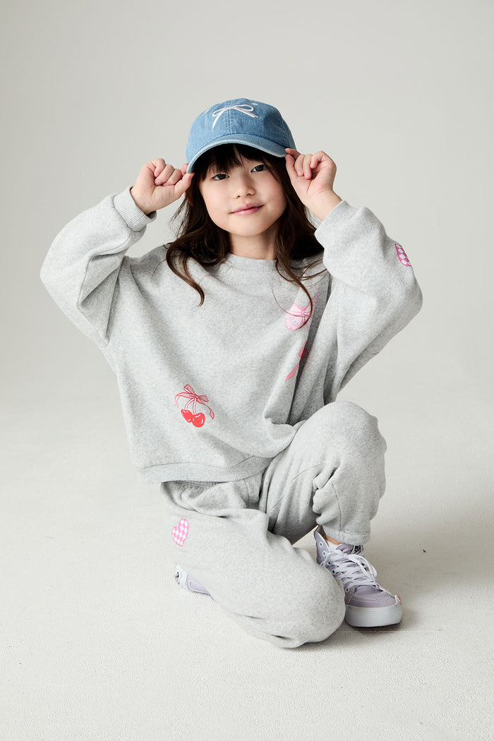 Girl crouching down wearing the Chaser irl Power Medley Girls Long Sleeve on a neutral background and matching pants and hat