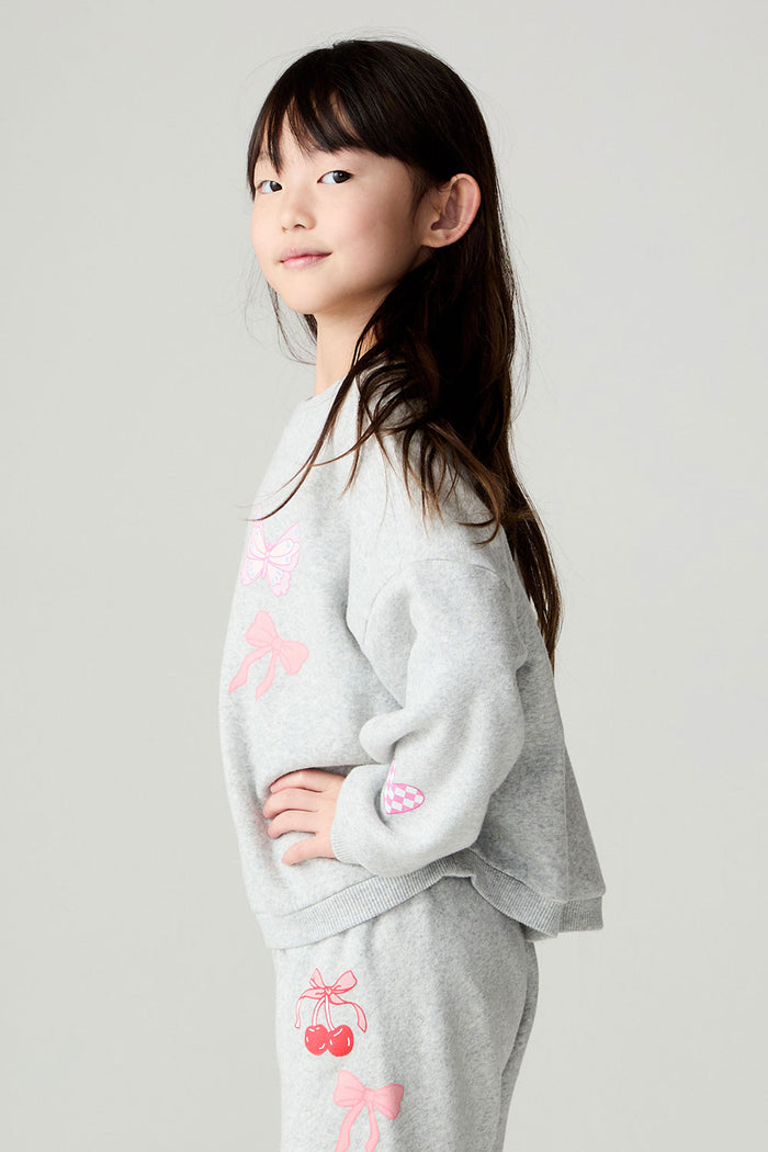 Side view of a girl wearing the Chaser irl Power Medley Girls Long Sleeve on a neutral background and matching pants