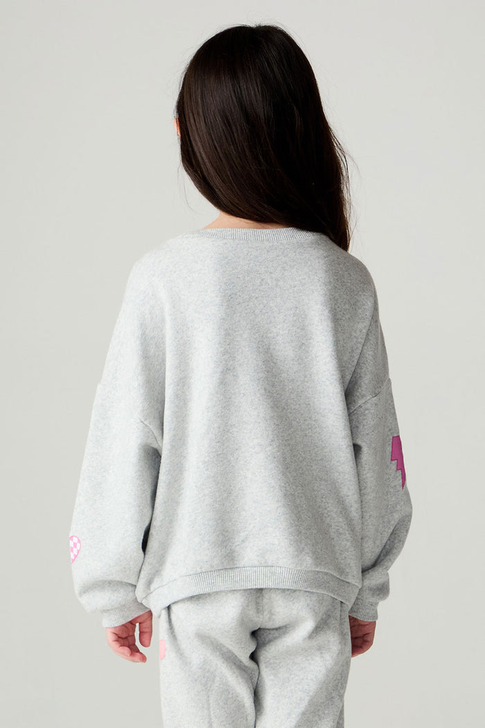 Back view of a girl wearing the Chaser irl Power Medley Girls Long Sleeve on a neutral background and pants