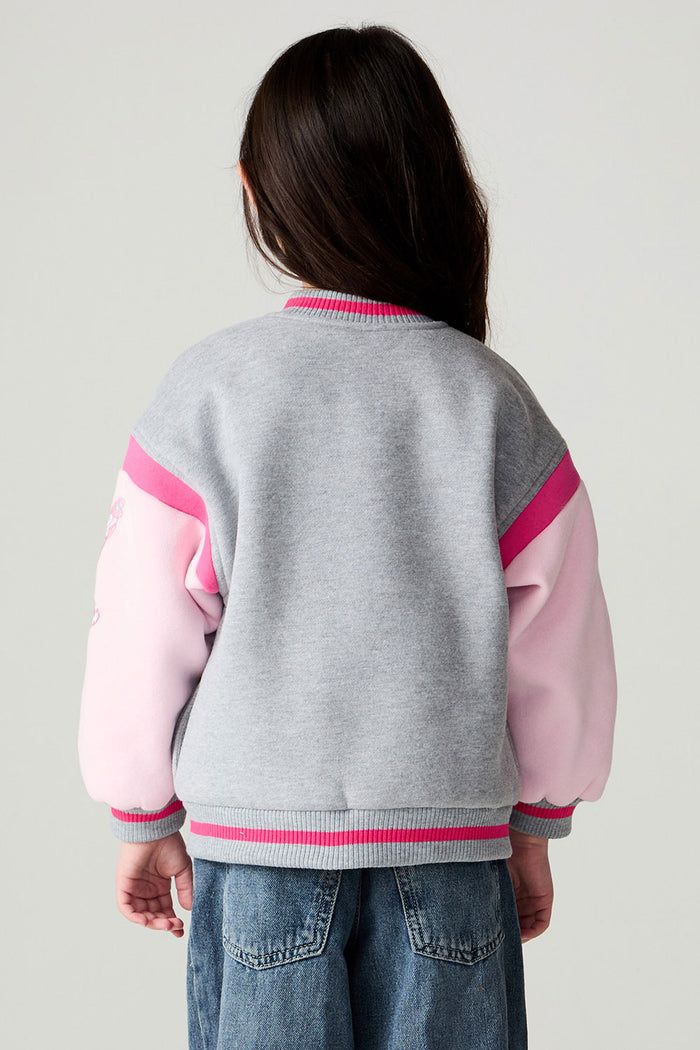 Back view of a girl wearing the Chaser Girl Power Medley Varsity Girls Varsity Jacket and jeans on a neutral background