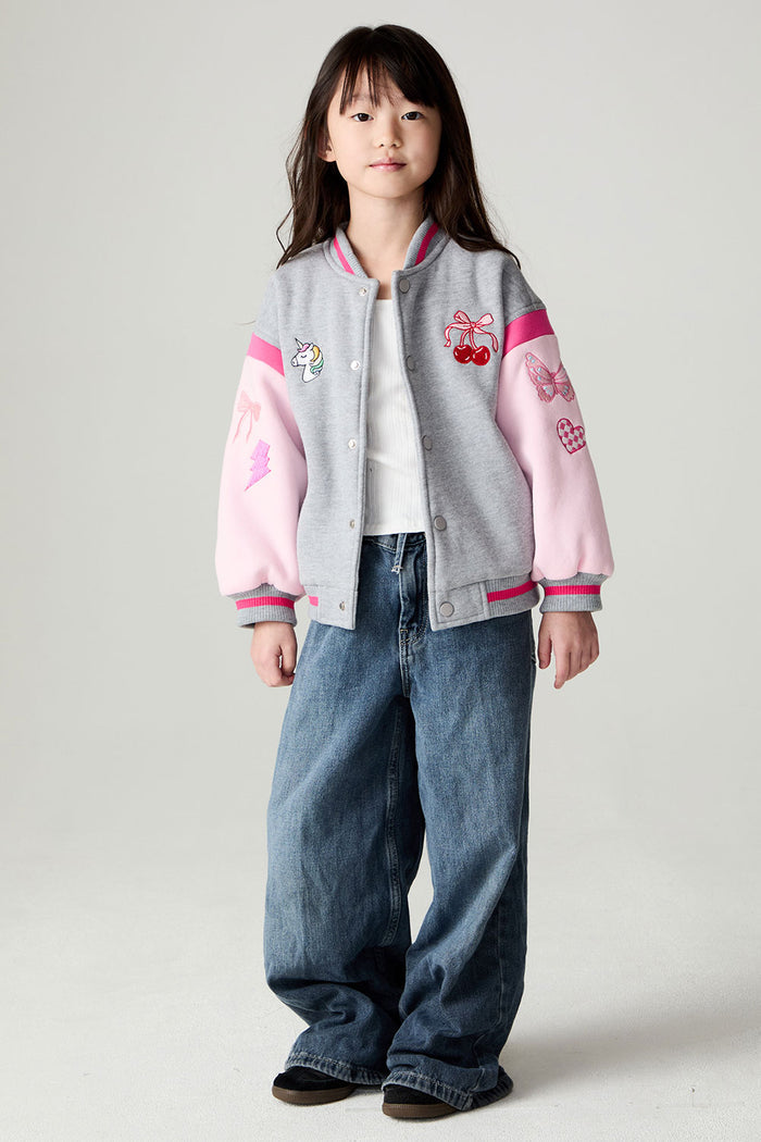 A full body front view of a girl wearing the Chaser Girl Power Medley Varsity Girls Varsity Jacket on a neutral background