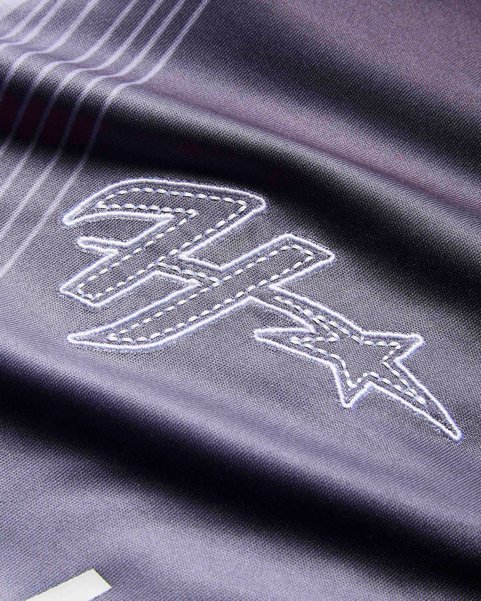 Close-up of a dark gray or black athletic fabric with white embroidered logo details, showing a stylized letter 'H' and star motif.