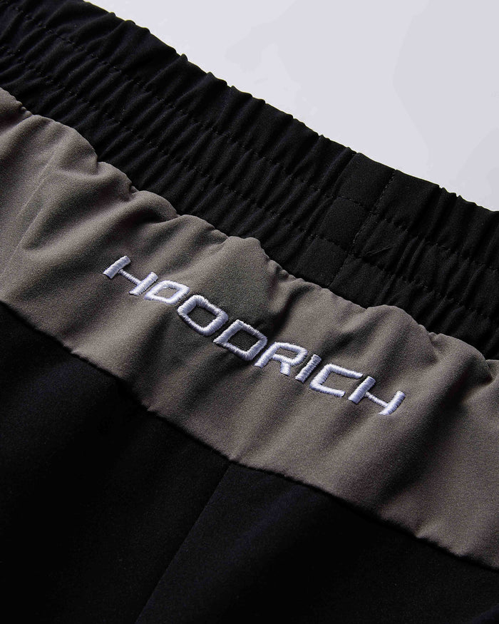 Close-up of a garment with 'Hoodrich' branding on a black and gray background