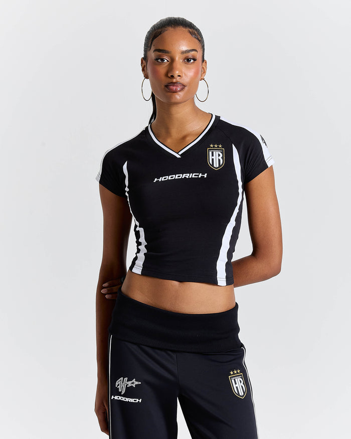 Woman wearing a black sports outfit with visible branding on a white background