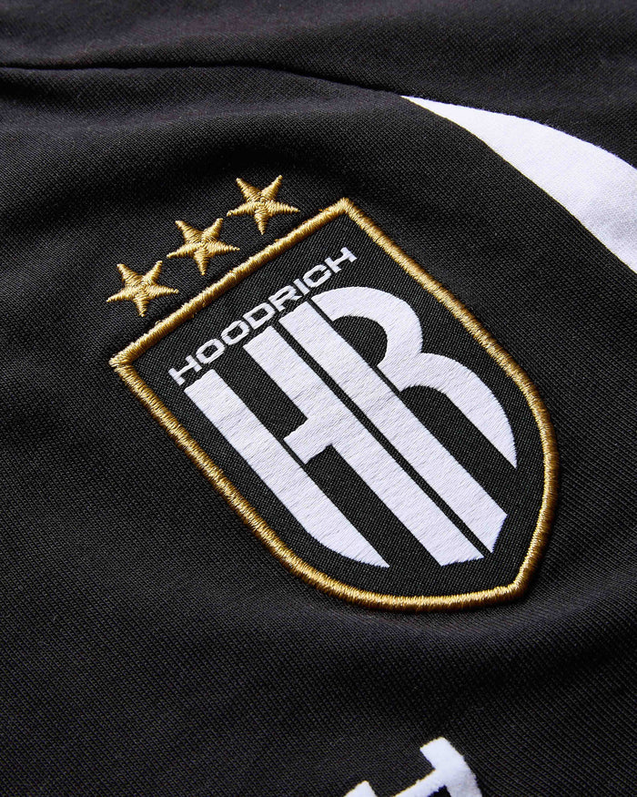 Close-up of a black jacket with an embroidered logo featuring stars and 'Hoodrich' text.