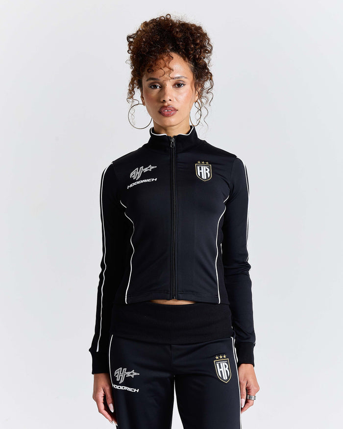 Person wearing a black tracksuit with white accents on a light gray background
