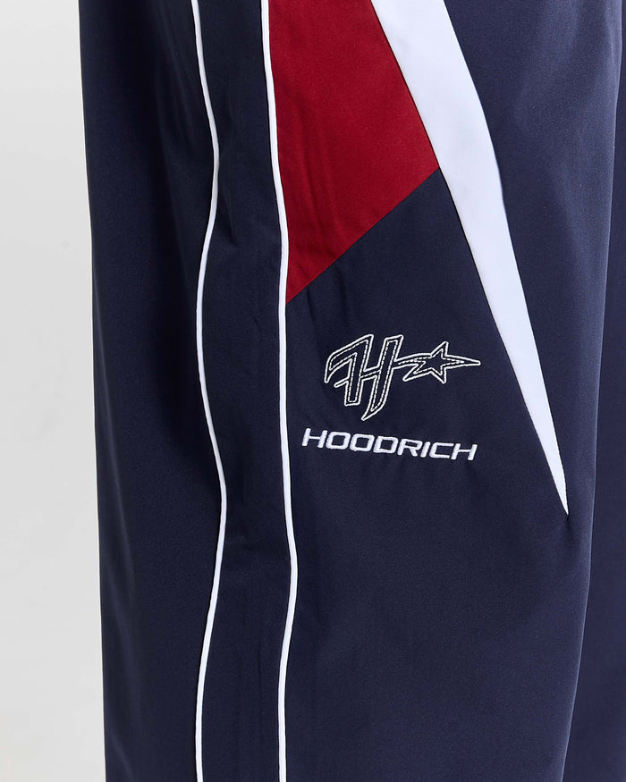 Navy blue pants with red and white accents featuring a logo and text on a light gray background