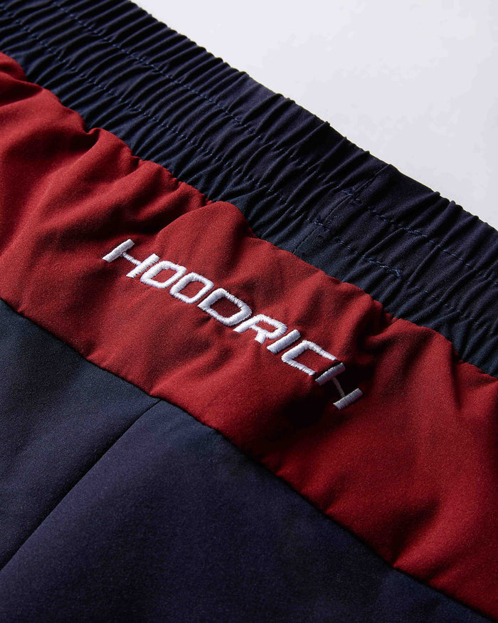 Close-up of a red and navy jacket with 'Hoodrich' branding on a white background
