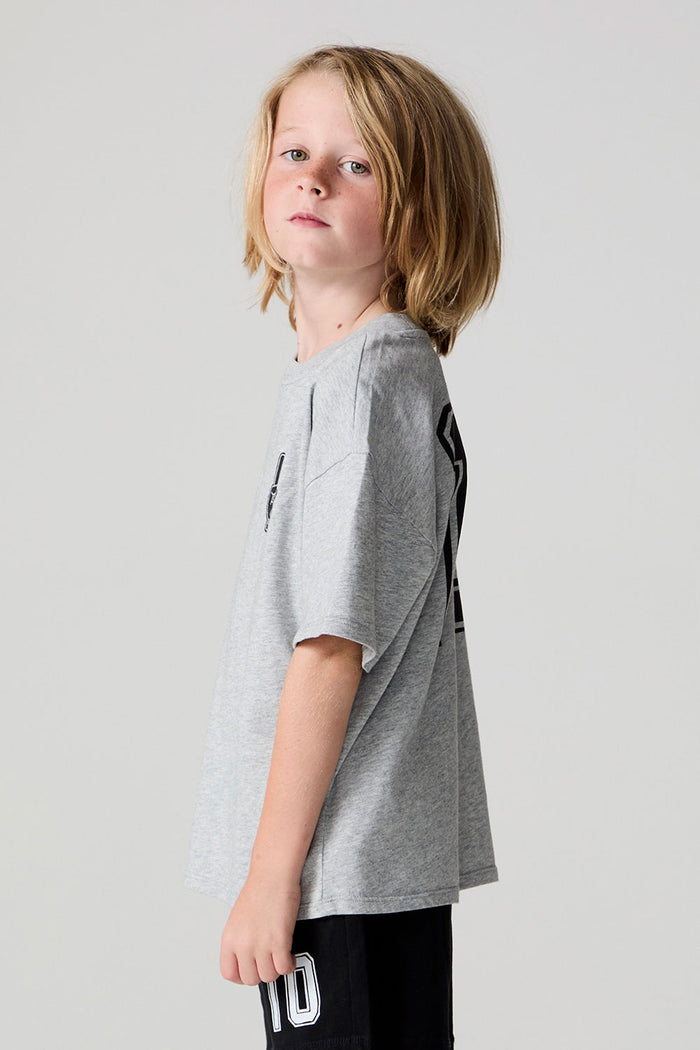 Side view of a boy wearing the Chaser Go Team Tee  on a neutral background