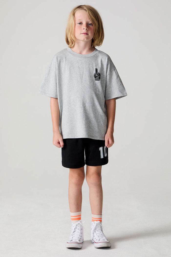 Full body front view of a boy wearing the Chaser Go Team Tee  on a neutral background