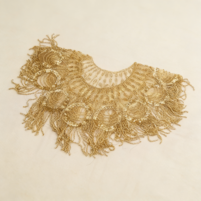 Gold beaded bridal capelet with hand embroidered sequins and flowing fringe on illusion mesh for luxury weddings.