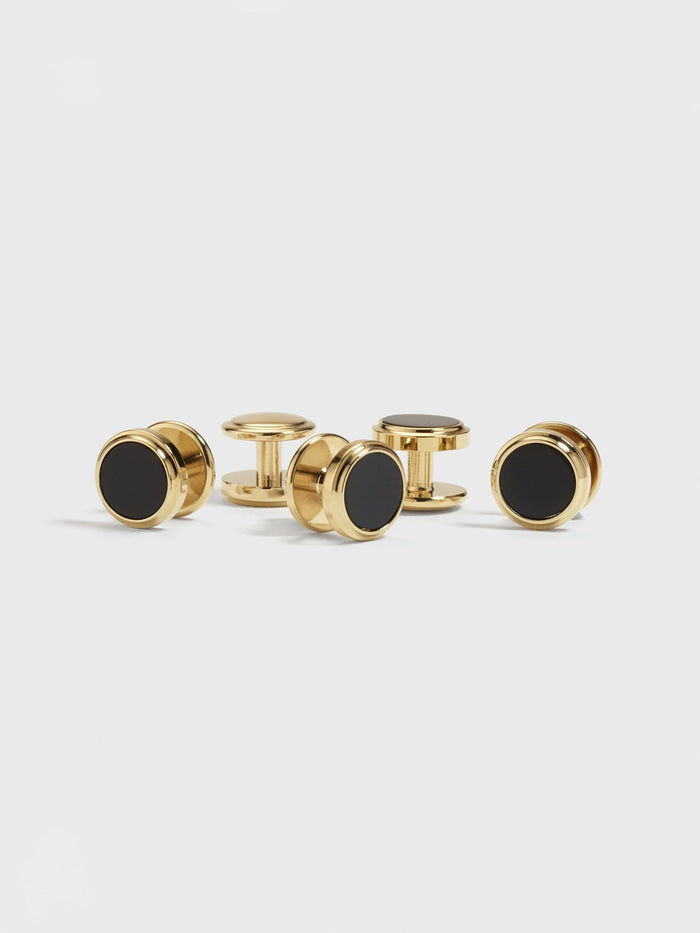 Five gold button studs with black onyx centers on a white background.