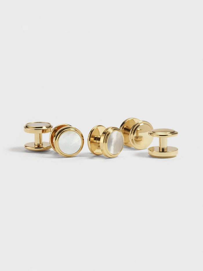 Five gold button studs with mother-of-pearl centers.