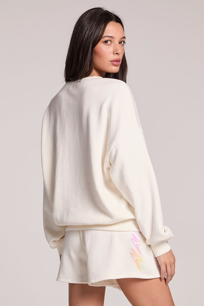Back view of a woman wearing the Chaser Gradient Bolt Pullover on a neutral background