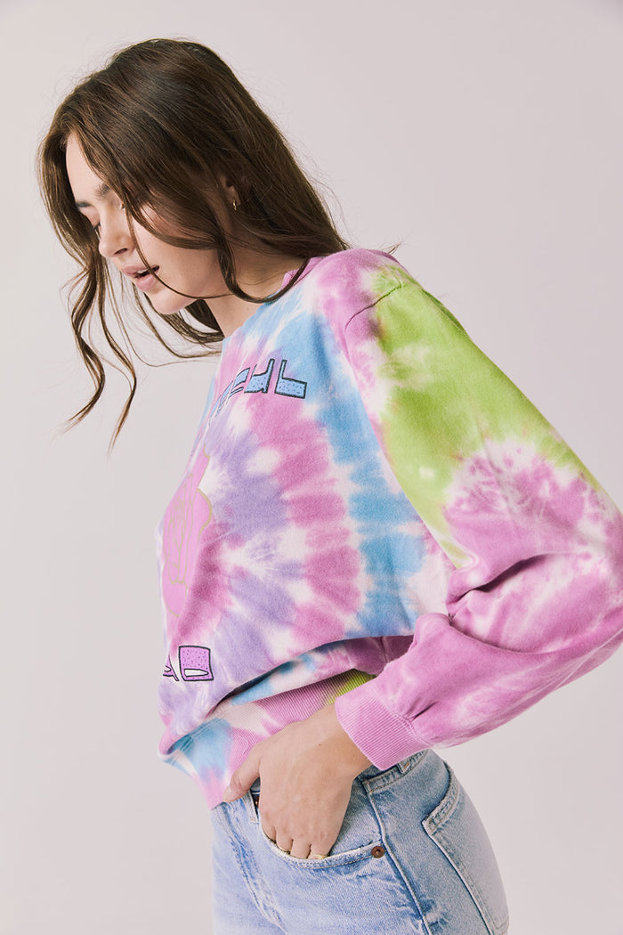 Side view of woman wearing Chaser’s Grateful Dead Rose Logo Long Sleeve with tie-dye pattern on a plain background