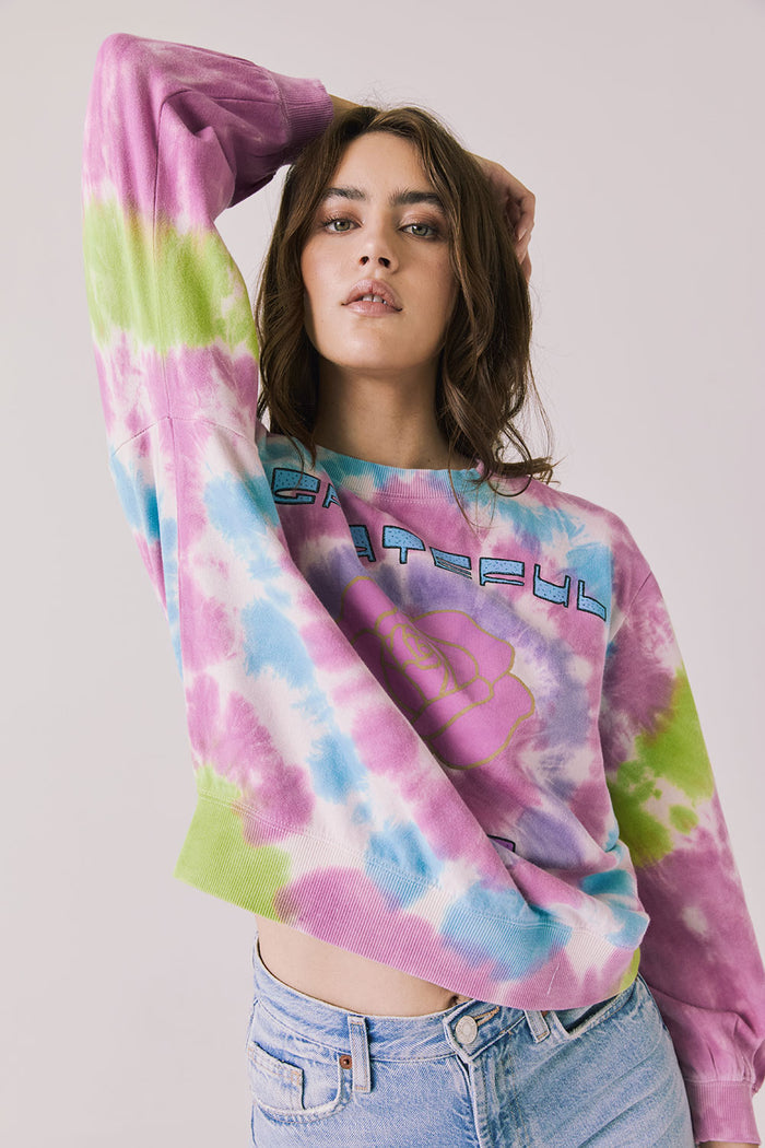 Front view of woman wearing Chaser’s Grateful Dead Rose Logo Long Sleeve with tie-dye pattern on a plain background