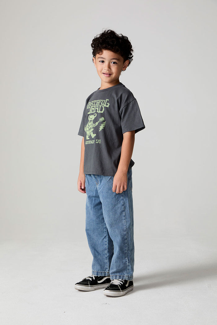 Full body side angle view of a boy wearing the Chaser Grateful Dead Tour Tee on a neutral background