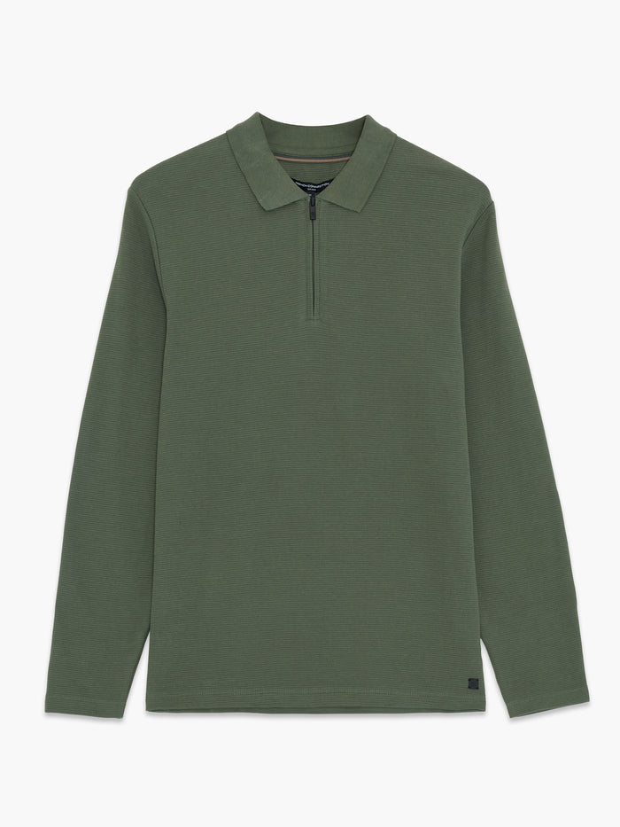 A man wearing a green ottoman texture Polo shirt with long sleeves, a collared neckline, a branded half zip and a regular fit.
