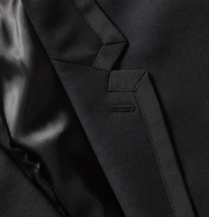 Close-up of black tuxedo jacket satin lapel binding and besom pocket trim