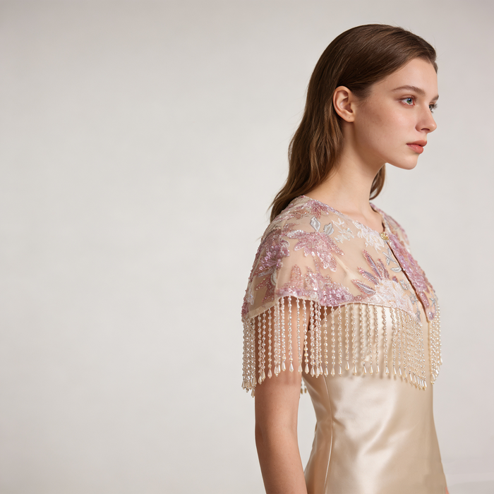 Elegant blush pink bridal shoulder cape with floral embroidery, delicate beadwork, and flowing pearl fringe.