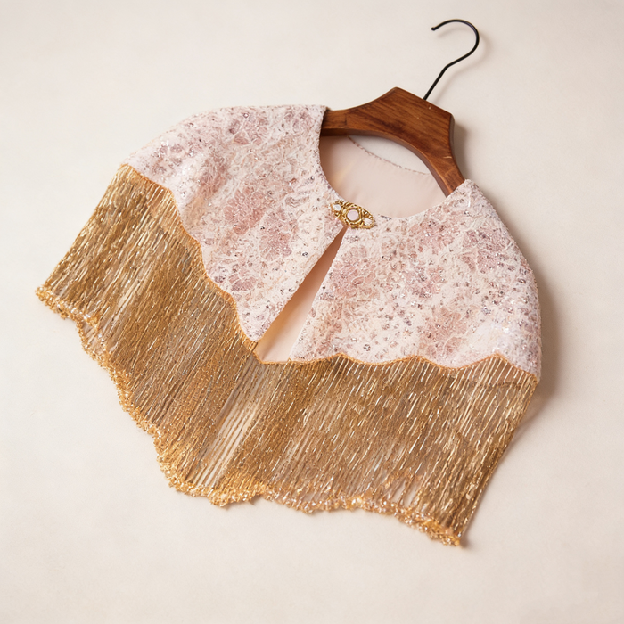 Handmade bridal shoulder cape featuring champagne gold fringe, blush embroidery, shimmering sequins, and delicate seed bead embellishments.